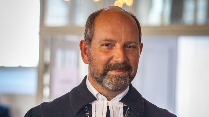 Ein Richter in Amtstracht hält eine Mappe