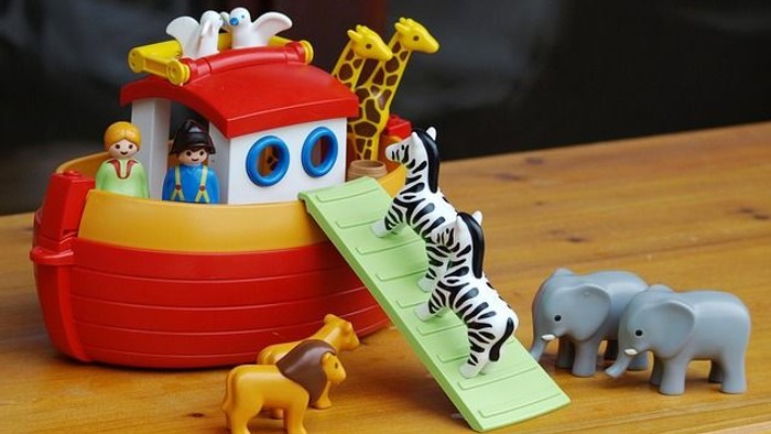 Buntes Noahs-Arche-Spielset mit Tieren und Figuren, die aus dem Boot klettern.
