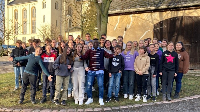 Eine Gruppe von Menschen posiert vor einem Gebäude.