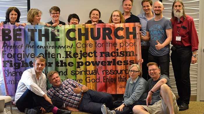 Eine Gruppe von Menschen hält ein großes Banner mit der Aufschrift