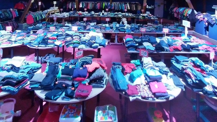 Tisch mit ordentlich gefalteter Kleidung in verschiedenen Farben und Arten.