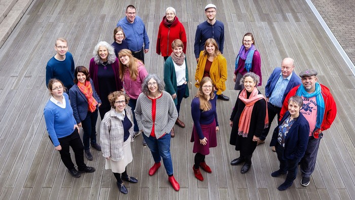Eine Gruppe von Menschen posiert auf einem Holzfußboden