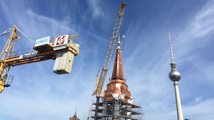 Baustelle mit Kranen und Fernsehturm.