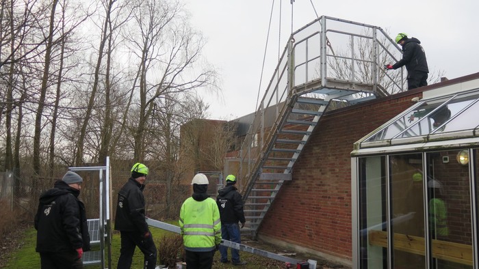 Arbejdere installerer trappe på hus.