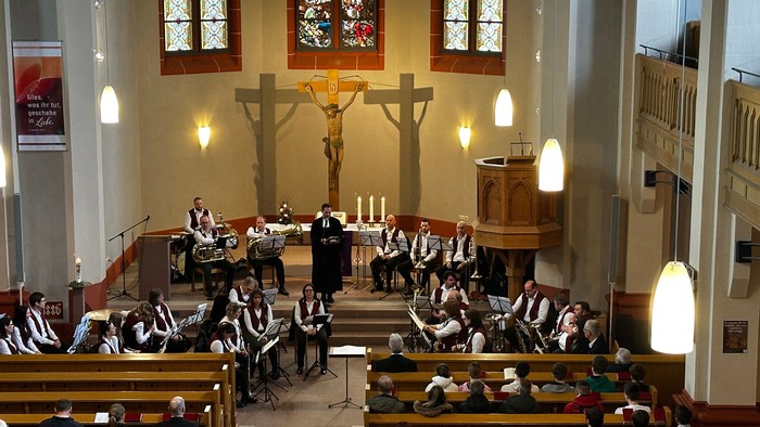 In der Kirche findet eine Messe statt, viele Gläubige sind anwesend.