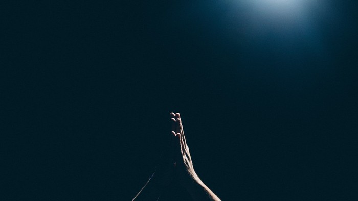 Silhouette eines Berggipfels vor hellem Himmel.