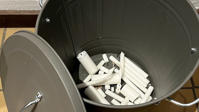 En grøn asbestskål med mange lyse cigaretter.