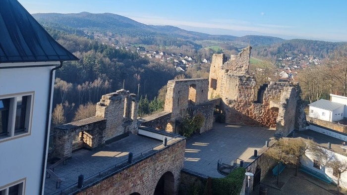 Altes Schloss auf Hügel, Dorf und Berge im Hintergrund