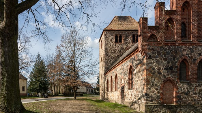 Altes Steingebäude mit Ziegeldach in parkähnlicher Umgebung