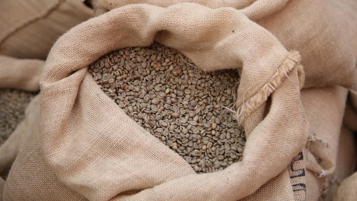 En stor burlap-sack med kaffe-bønner.