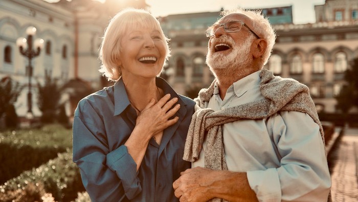 Ein älteres Paar lacht herzlich in der Stadt