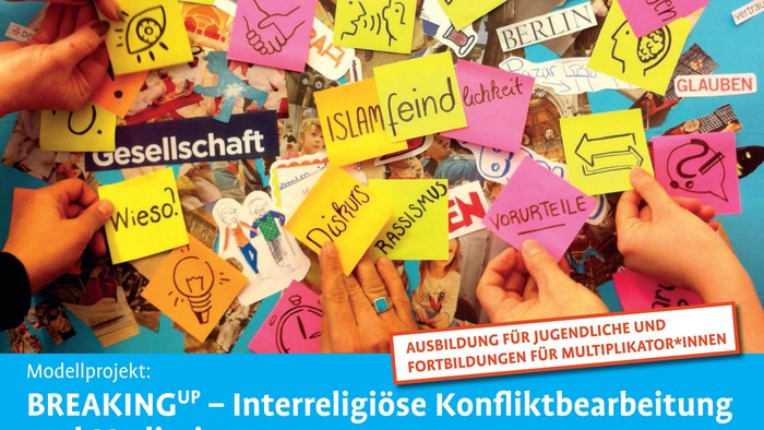 Viele Hände halten bunte Zettel mit Wörtern und Zeichnungen, darunter Begriffe wie