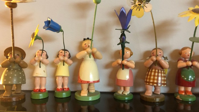 Eine Sammlung von Holzfiguren, die Blumen halten