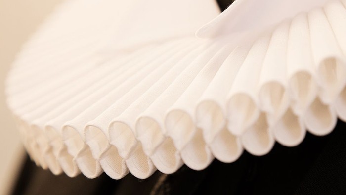 En række hvidt papirfingre, lagt sammen i en kurveret form