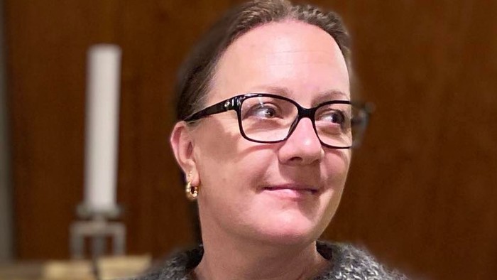 Kvinde med briller og halskæde.