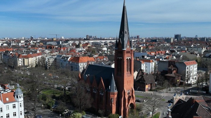 Die Stadtlandschaft mit einer markanten roten Kirche und vielen Gebäuden.