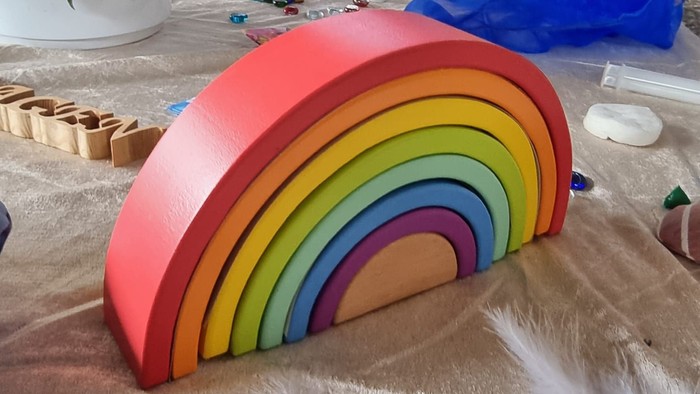 Bunter Holzregenbogen auf Tisch mit verschiedenen Gegenständen