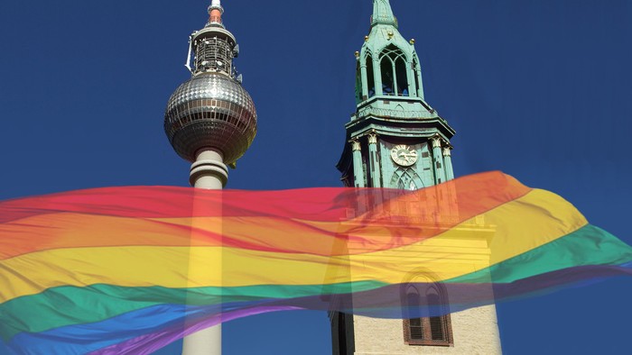 Bunter Regenbogenfahne vor Berliner Fernsehturm und Kirche