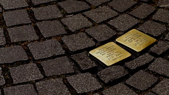 Goldene Stolpersteine-Gedenktafeln, eingelassen in Kopfsteinpflaster.