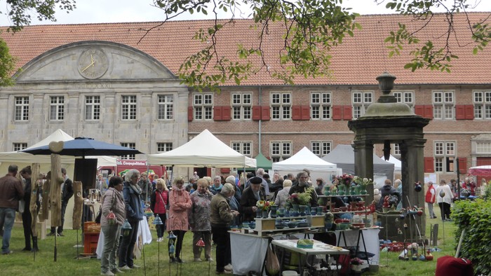 Markttag vor historischem Gebäude mit vielen Besuchern und Ständen