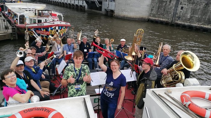 Eine Gruppe von Musikern spielt auf einem Boot am Wasser