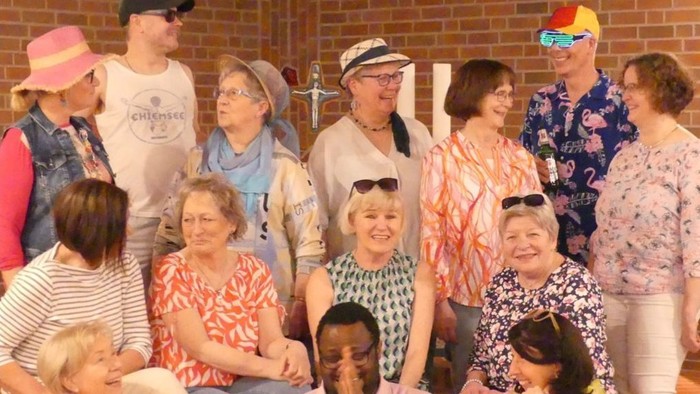 Das Buchcover zeigt eine Gruppe von Menschen bei einem Sommerkonzert, mit einem farbenfrohen Hintergrund und Text in Deutsch.