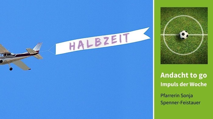 Ein Flugzeug zieht ein Banner mit der Aufschrift "HALBZEIT" über einem Fußballfeld
