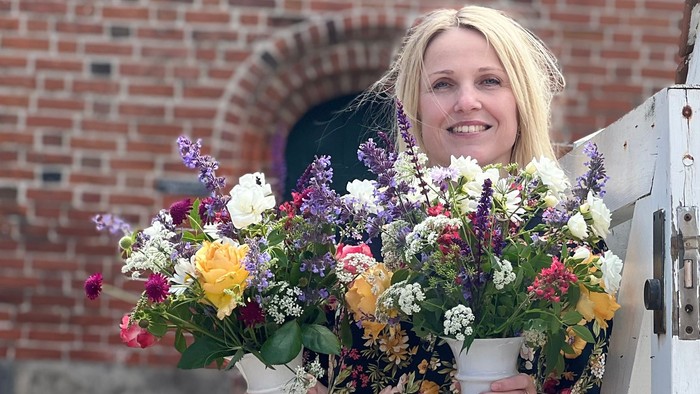 Kvinde med blomsterstang i armene.