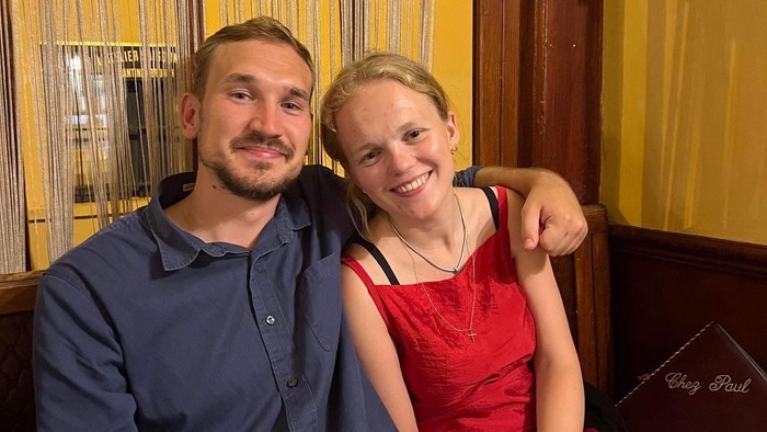 En mand og en kvinde smiler til kameraet i et restaurant.