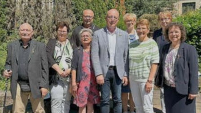 Gruppe von Menschen, die gemeinsam im Freien posieren.