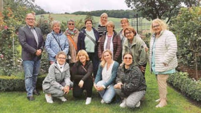 Gruppe von Personen, die im Freien in einem Garten posieren.