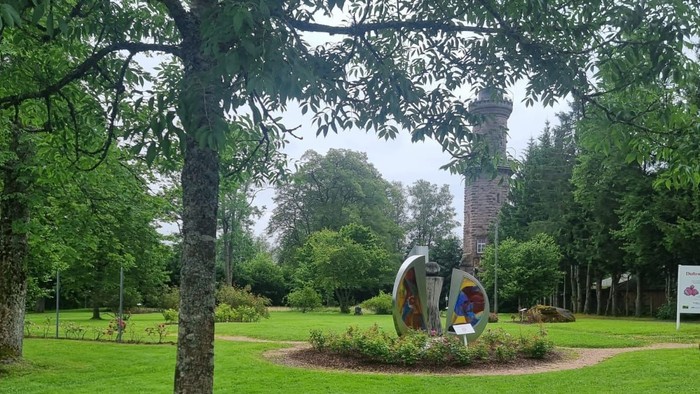 Im Park steht eine Statue auf einem kreisförmigen Beet.