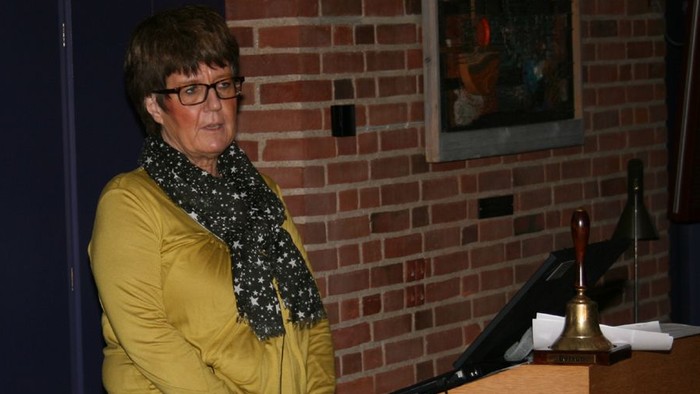 Kvinde ved pulpet med laptop og mikrofon