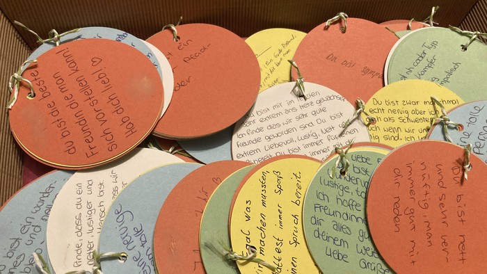 Viele farbige Pappteller mit handgeschriebenen Nachrichten