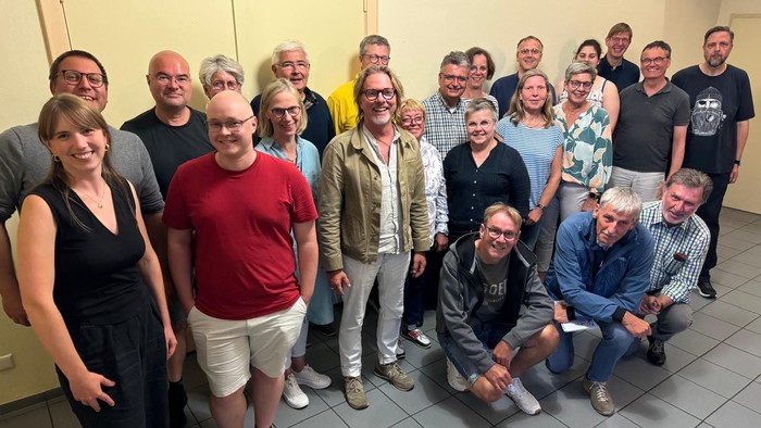 Eine Gruppe von Menschen posiert für ein Gruppenfoto in einem Raum