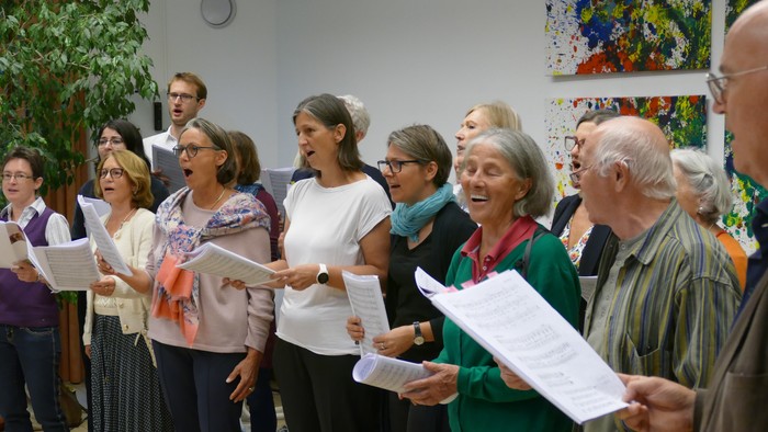 Eine Gruppe von Menschen singt aus Notenblättern
