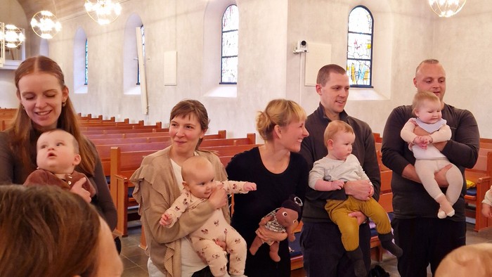 En gruppe af voksne og børn i en kirkehal