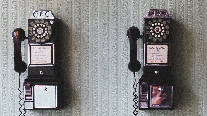 Drei alte Telefone hängen an der Wand