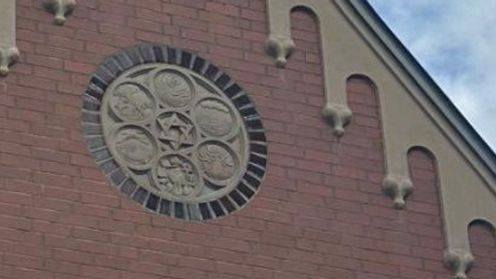 Das Bild zeigt die Fassade einer Synagoge mit einem Davidstern und einem Rundbogenfenster