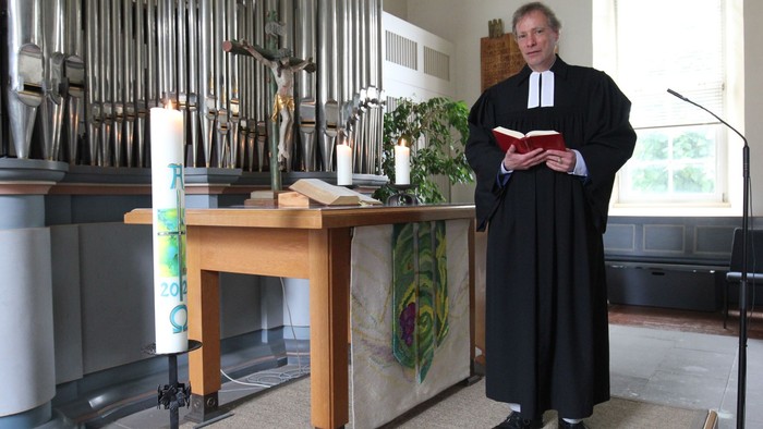 Ein Priester hält ein Buch in einer Kirche