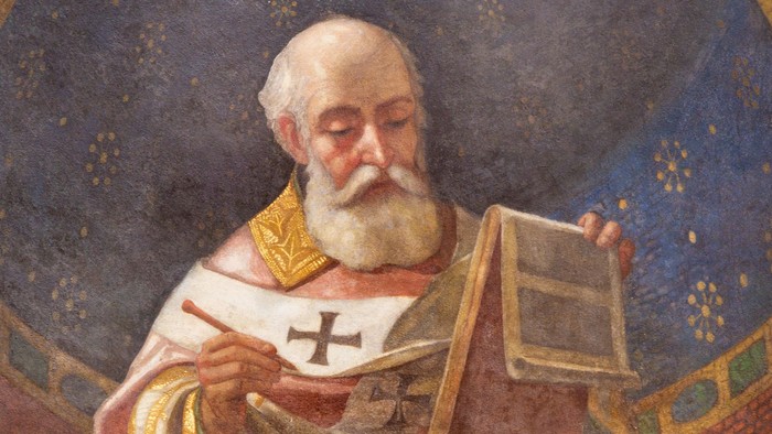 Ein alter Mann mit langem Bart liest in einem Buch, umgeben von verzierten goldenen Mustern