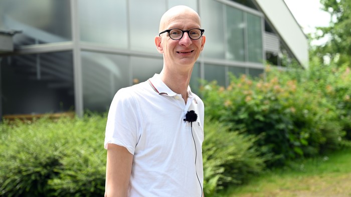 Mann in weißem Hemd vor modernem Gebäude