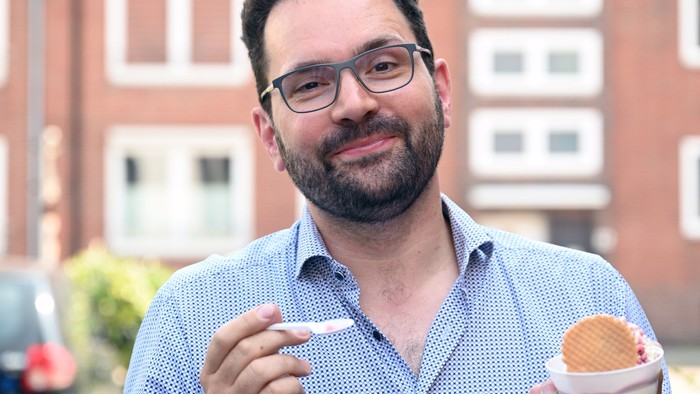 Mann hält zwei Donuts und lächelt