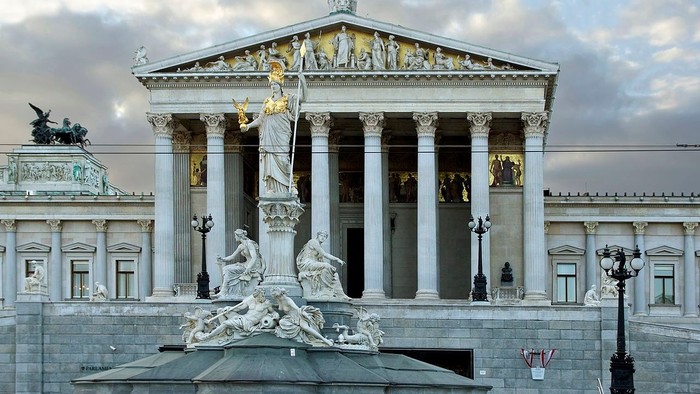 Prächtiges Gebäude mit Säulen und Statue vor dem Parlament