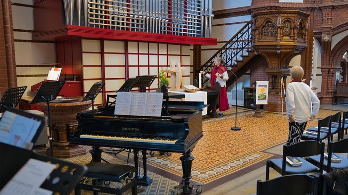 Kirchliche Innenraum mit Klavier und Menschen