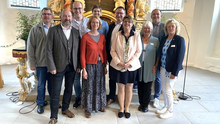 Eine Gruppe von Menschen posiert in einem Raum mit goldenen Dekorationen