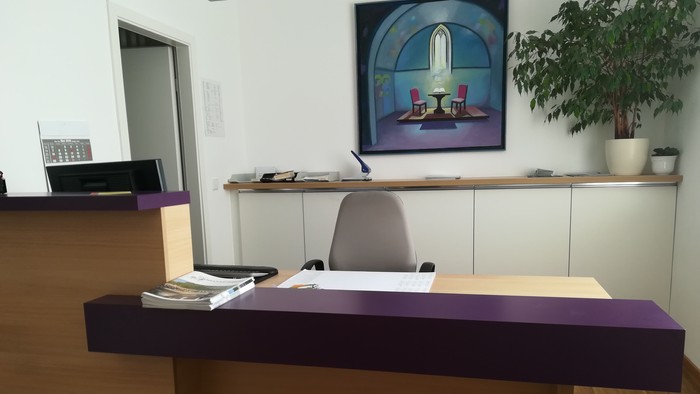 Modernes Büro mit Empfangstresen, Stuhl und Bild an der Wand