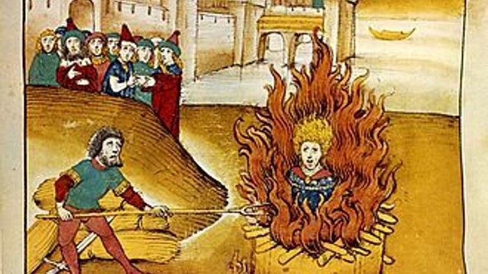 Ein Mann wird auf einem Scheiterhaufen verbrannt, während andere ihn beobachten.
