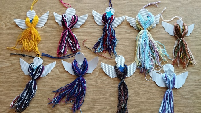 Bunte Garnengel mit Flügeln auf Holzfläche gelegt