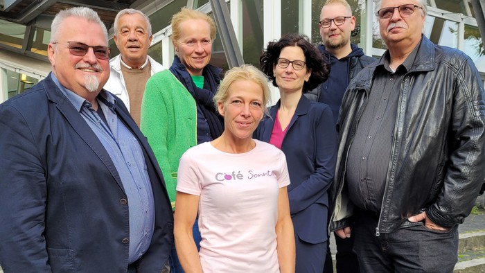 Eine Gruppe von Menschen posiert vor einem Gebäude